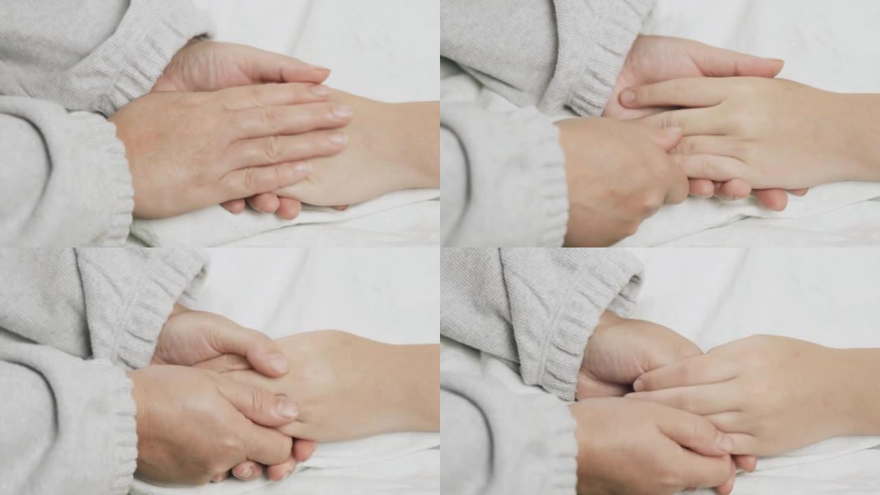 妈妈握着一个生病的少女的手，抚摸她的手，鼓励。