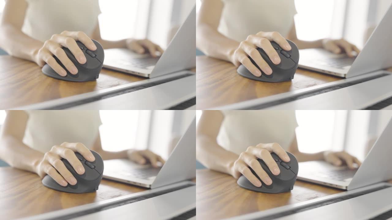 女人手使用电脑符合人体工程学的鼠标，防止手腕疼痛，因为工作时间长。De Quervain s腱鞘炎，