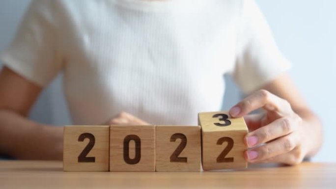 手换2022换2023年年号在桌子上。目标，决议，战略，计划，开始，预算，任务，行动，动力和新年概念