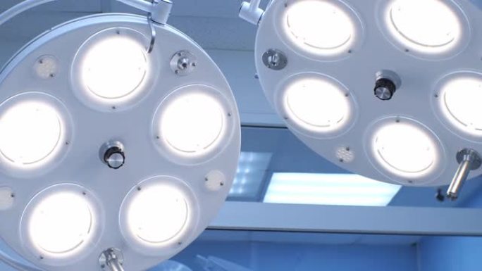 在手术中，手术台上方的灯明亮得令人眼花缭乱。从底部看，从手术台看。灯耀眼起来，刺眼。