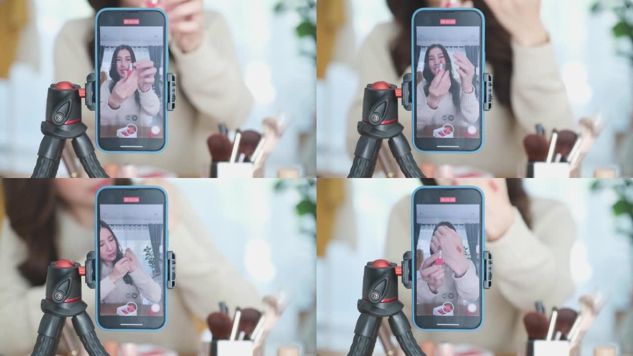 年轻的亚洲女性美容化妆艺术家vlogger，博客作者录制化妆教程，通过智能手机在网站和社交媒体上分享