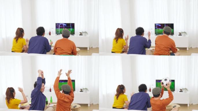 一群亚洲男女朋友一起在家看电视上的体育比赛。