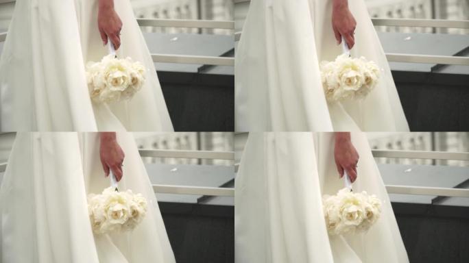 新娘拿着白色花束的特写镜头。