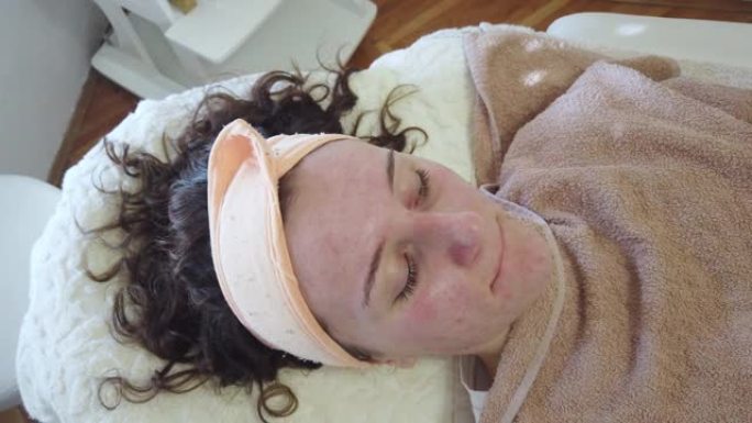 有痤疮问题的年轻女子在皮肤科办公室或美容院接受面部治疗。