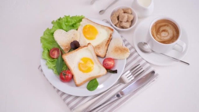 女人将新鲜制作的鸡蛋入洞吐司和新鲜的热咖啡放在桌子上