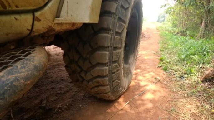 4x4越野皮卡汽车车轮在土路上行驶。越野卡车汽车车轮在肮脏的道路上移动，有灰尘、湿和干泥浆。在偏远地