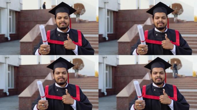 快乐的印度学生毕业生带着文凭站在楼梯上，在大学校园里竖起大拇指