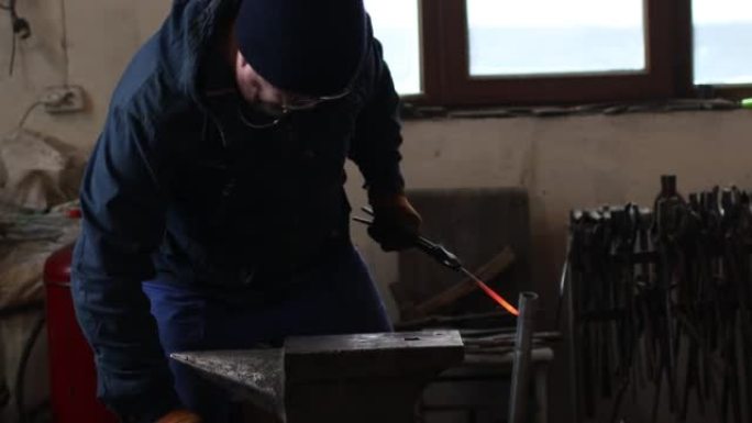铁匠用铁锤和铁砧锻造并制作箭头箭头金属细节。