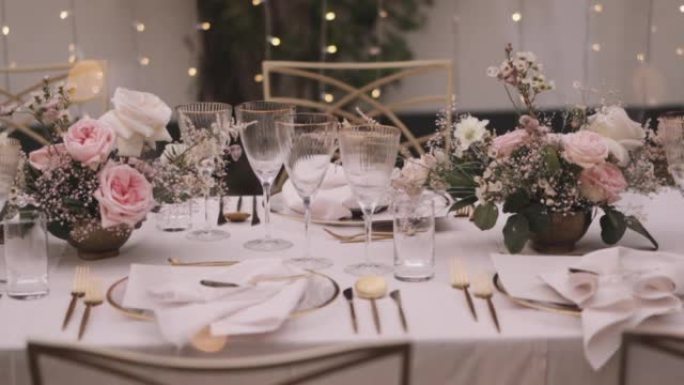 婚礼用金色和玫瑰餐桌装饰的餐厅内部