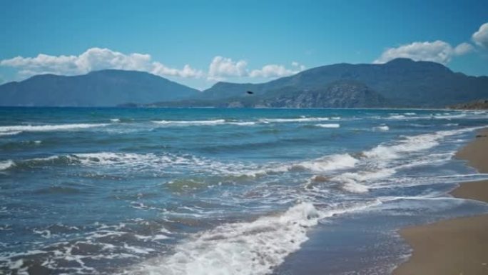 在土耳其美丽的沙滩空旷的海滩Iztuzu，阳光明媚的夏日风日，海浪挥舞着大海。