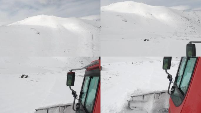 雪猫ratrack用扫雪机准备滑雪场，驶过滑雪胜地的深雪道。重型机械运输山峰上的自由式滑雪者
