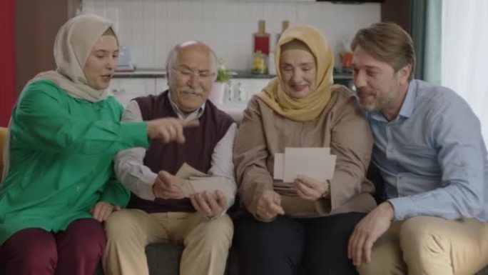 幸福的穆斯林大家庭通过看老照片来回忆他们的记忆。