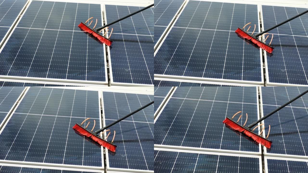工人用刷子和水清洁太阳能电池板。清洁和绿色替代能源概念。