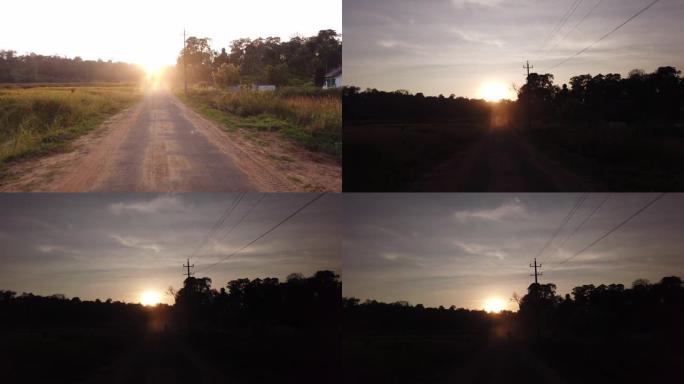 4k慢动作的阳光照射在印度卡纳塔克邦绿色田野之间的道路上