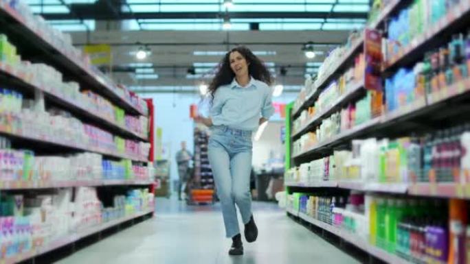 商店里开朗的年轻女性顾客在超市里的行之间跳舞有趣，走在杂货店里，一边跳舞，一边购物，时髦的女性疯狂舞