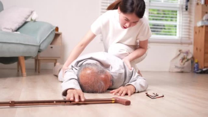 亚洲女性女儿或孙女帮助老年男性在家中客厅摔倒。年老的老爷爷在接受物理治疗后心脏病发作