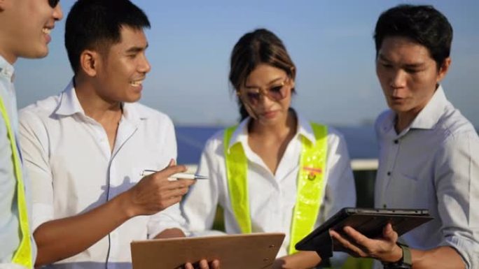 特写镜头，一组亚洲工程团队在计划操作和光伏太阳能电池板时使用平板电脑，年轻的检查员工程师男性和女性同