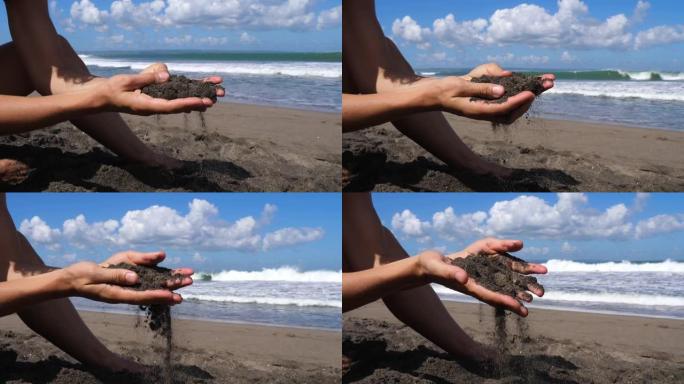 女性双手的特写镜头，在蓝天和海洋的背景下，她们握住沙子，试图用指尖感受每一粒谷物。然后通过手指慢慢释