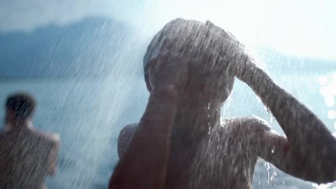 小男孩在户外湖边洗冷水澡。男孩子站在外面用超级慢动作的水清洗身体