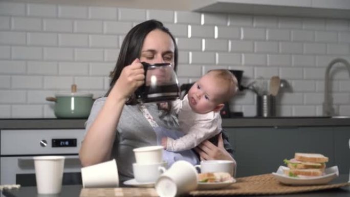 精疲力竭的女人带着婴儿在家喝咖啡