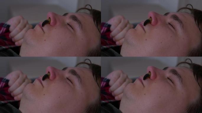 绿色鼻涕虫爬进睡人的鼻孔，侧视，特写。
