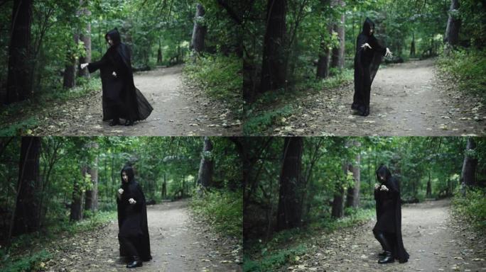 一个穿着黑色斗篷的女人在阴暗的森林里跳舞。有趣的女巫
