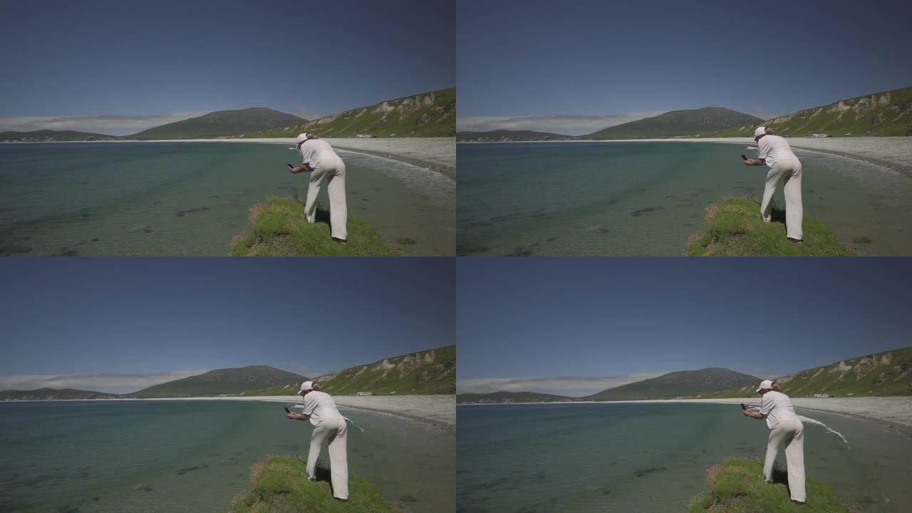 白人妇女在爱尔兰阿基尔岛龙骨海滩的一块小土地上拍摄视频