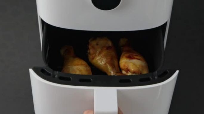 空气炸锅里美味的鸡腿，特写。家用厨房烹饪的现代技术