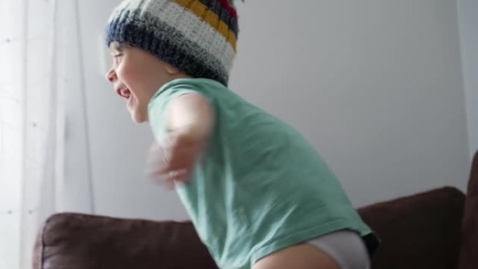 一个快乐的小男孩在室内穿着针织羊毛豆豆。可爱的孩子穿冬季配饰