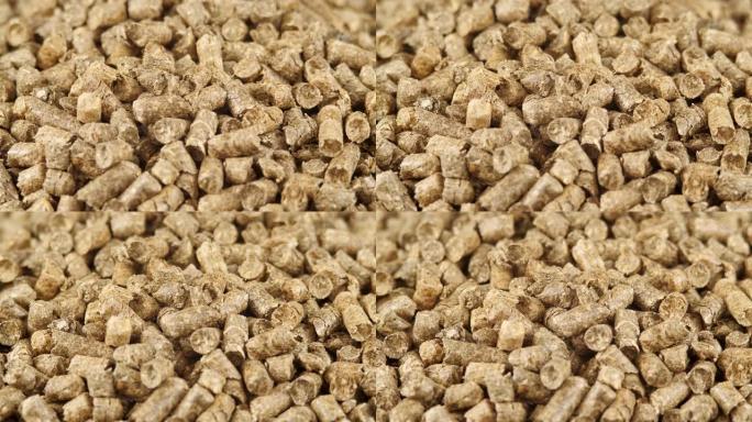压实秸秆颗粒作为天然猫砂填料或有机燃料的特写旋转。茅草颗粒背景。可再生替代能源。寒冷季节加热材料