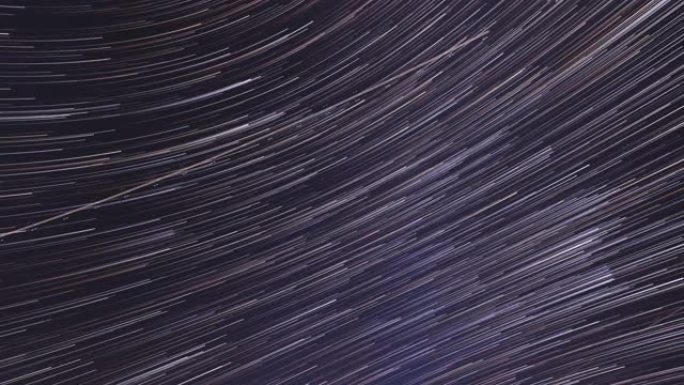 星迹迷人的幻觉。4k过度。天空中不寻常的惊人恒星效应的旋转。流星在夜色深蓝色的天空背景下追踪。延时，