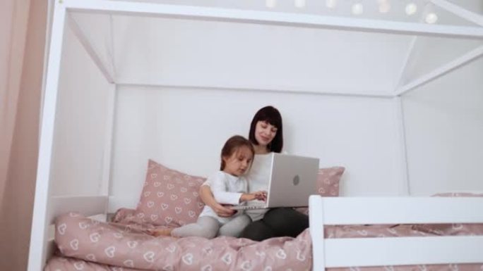 高加索母亲和可爱的学龄前女儿的肖像，使用笔记本电脑进行视频通话