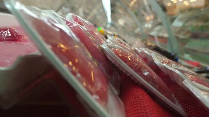 超市中单独包装，预先包装的红色生肉的特写镜头，放在配备特殊的冷藏透明展示柜中。