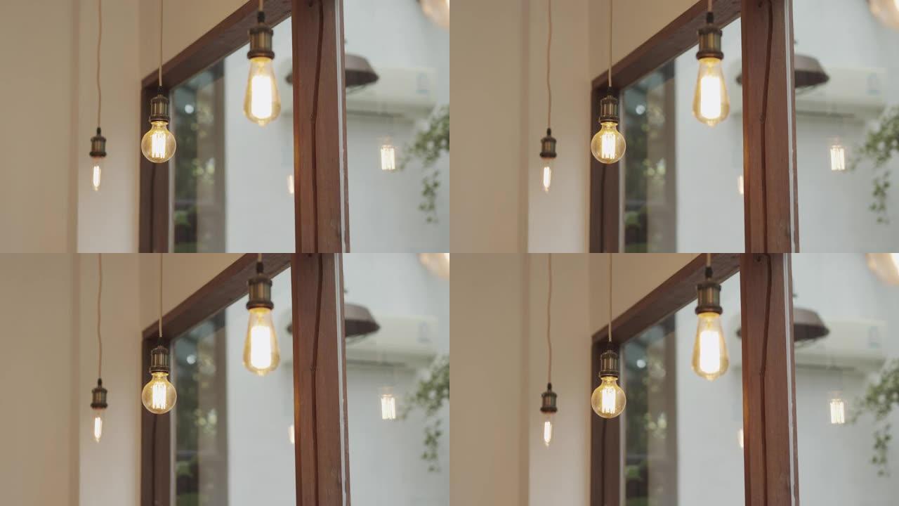 美丽的老式灯泡挂在客厅里，阳光透过窗户，展示了老式装饰的概念，为房子、咖啡店和餐厅提供舒适的氛围。