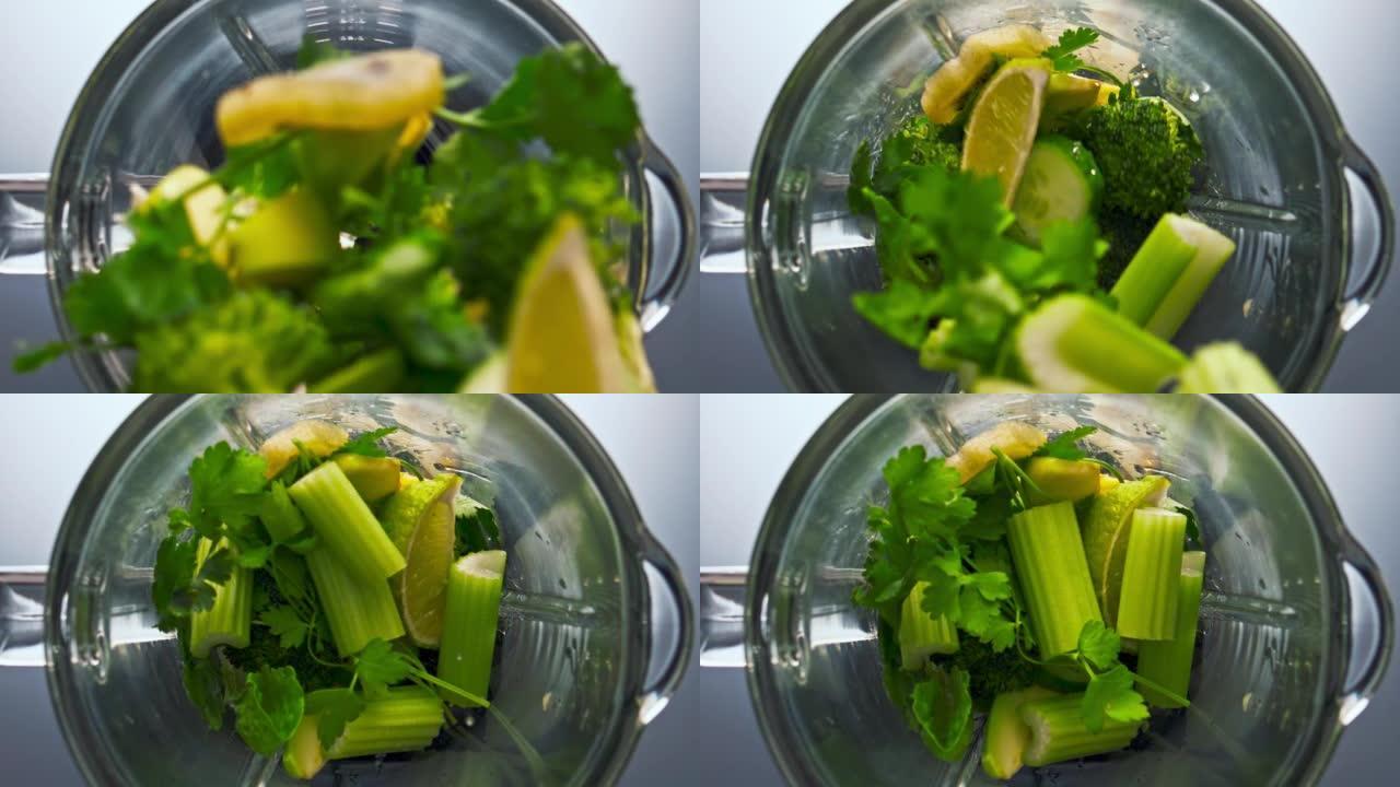 生绿色蔬菜坠落搅拌机在超慢动作特写。维生素食品。