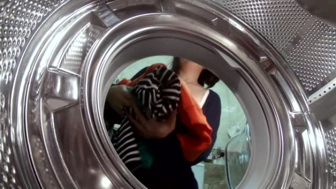 微笑的女管家在洗衣机里穿上衣服
