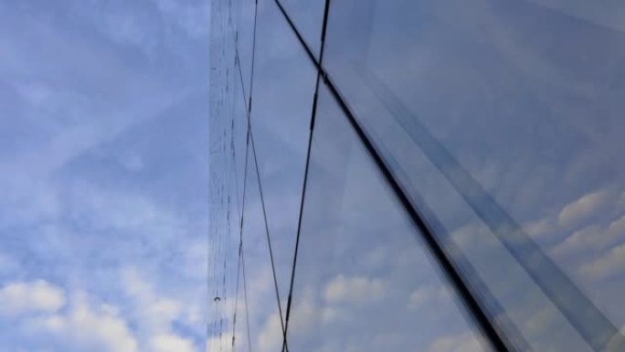位于首都中心的高大玻璃建筑。美丽的云彩映照在摩天大楼的窗户上。日落时的商业区