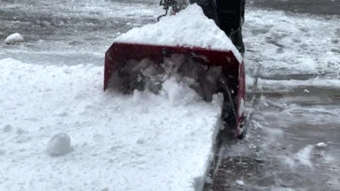 男子冬季用鼓风机、除雪设备清理道路