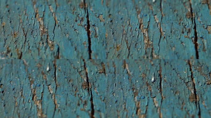 油漆剥落的木墙的缓慢垂直滑动拍摄。慢速多莉的旧彩绘木板，质地。