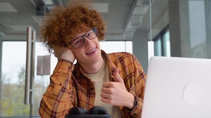 男性自由职业者在网上工作休息期间的肖像，时髦的博客作者坐在咖啡馆里，拿着笔记本电脑