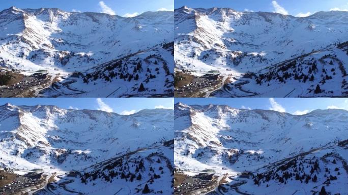 无人机飞越塞勒滑雪场的停车区，雪山之间有滑雪坡