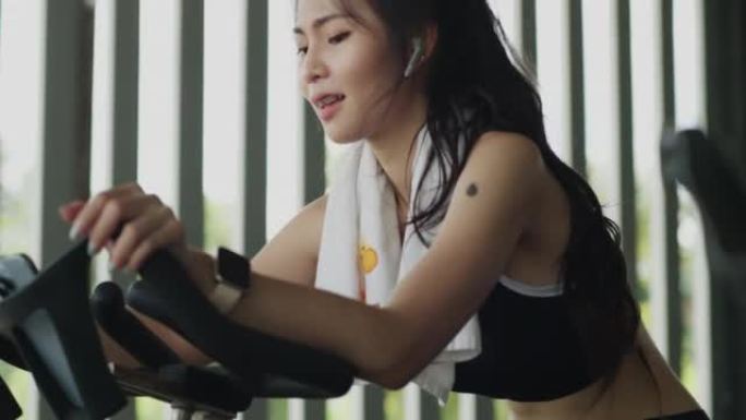 亚洲女子在健身房进行自行车训练