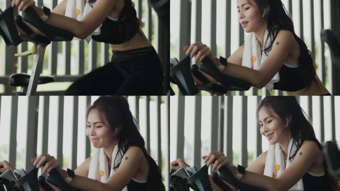 亚洲女子在健身房进行自行车训练