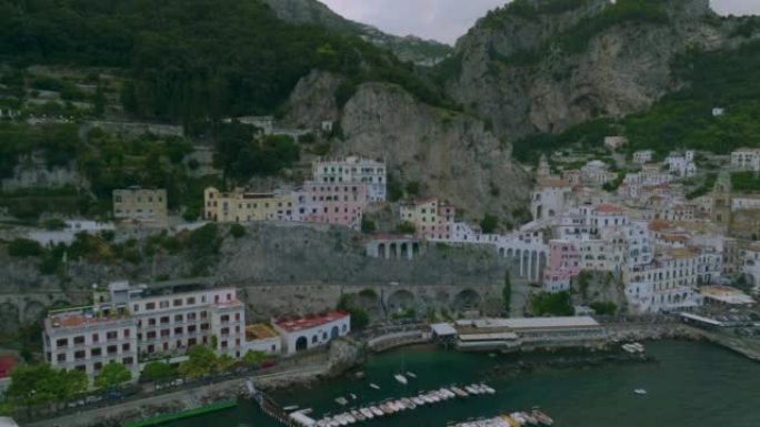 沿着海岸高大的岩壁建造的一排房屋的航拍镜头。旅游目的地的旅游地标。意大利阿马尔菲