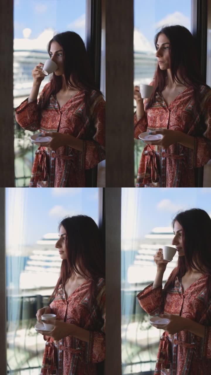早上从窗前的杯子里喝咖啡的女孩的剪影，在窗边喝茶的女人的剪影，穿着睡衣的女人正在看大海和游轮的景色，