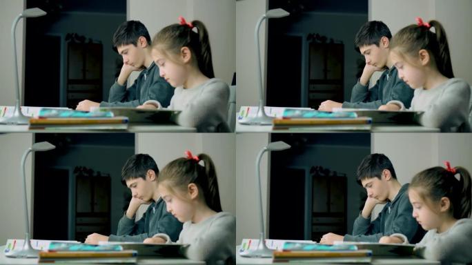 可爱的小女孩和她的哥哥男孩一起做作业，一起看书，坐在上面