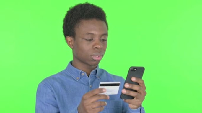 年轻的非洲男子在绿色背景下存在在线支付问题