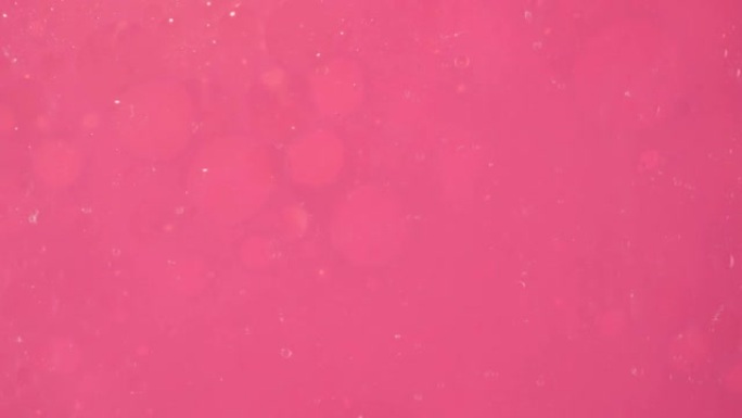 透明气泡沿着粉红色的较小气泡滑动，在粉红色背景上移动它们。一张用于广告的调剂成分