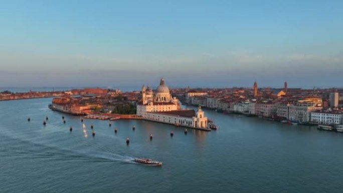 圣玛丽亚德拉致敬罗马天主教堂和小教堂的空中无人机日出场景，大运河和卡运河之间的交通船位于意大利威尼斯