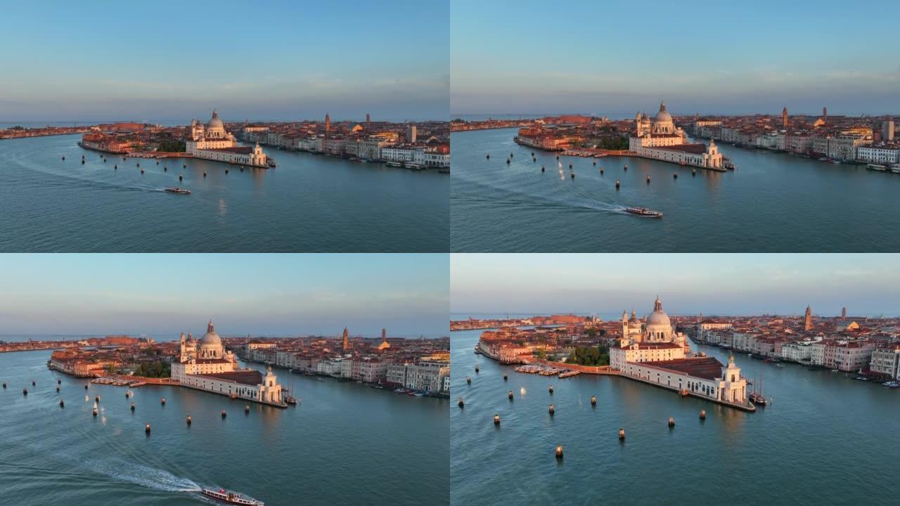 圣玛丽亚德拉致敬罗马天主教堂和小教堂的空中无人机日出场景，大运河和卡运河之间的交通船位于意大利威尼斯